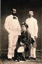 Portrait de studio ancien, deux hommes occidentaux en tenue claire encadrant une femme en kimono assise