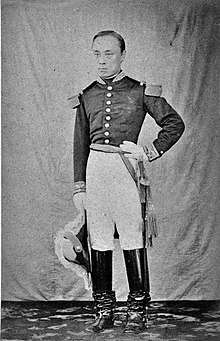 Portrait en pied d'un homme en uniforme militaire français, sabre au côté et bottes, main sur la hanche